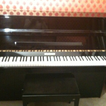 Piano droit Bruckner laqué noir en très bon état 